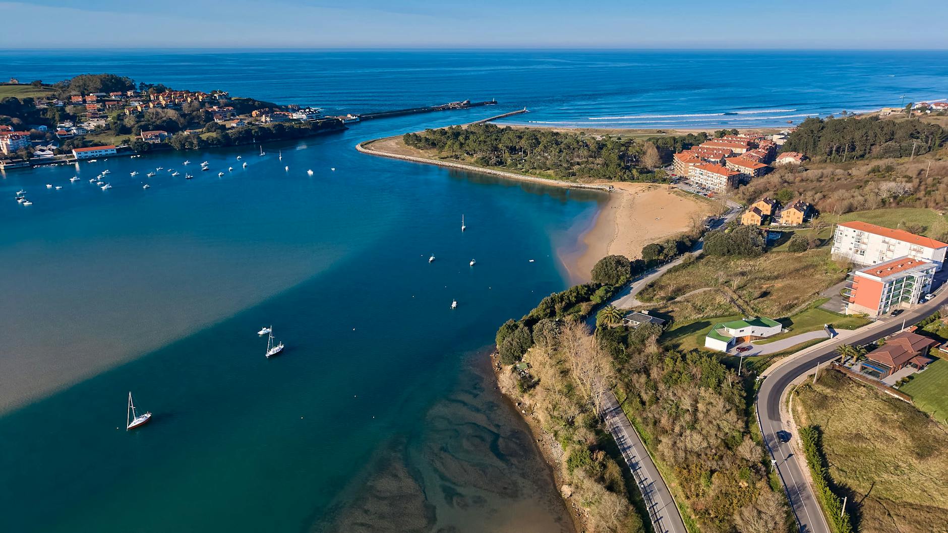 A breathtaking aerial view of Cantabria's coastline with the Cantabric Sea and coastal town.