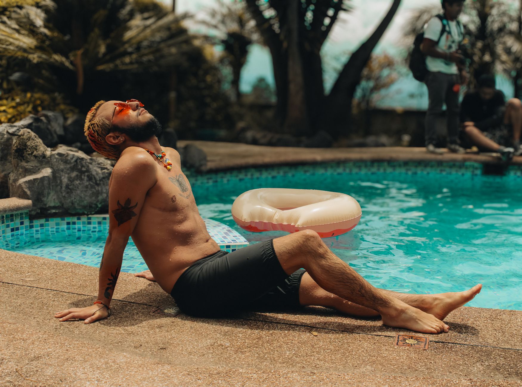 Man enjoying a sunny day by the pool in Quito, Ecuador. Perfect for summer vibes and relaxation themes.
