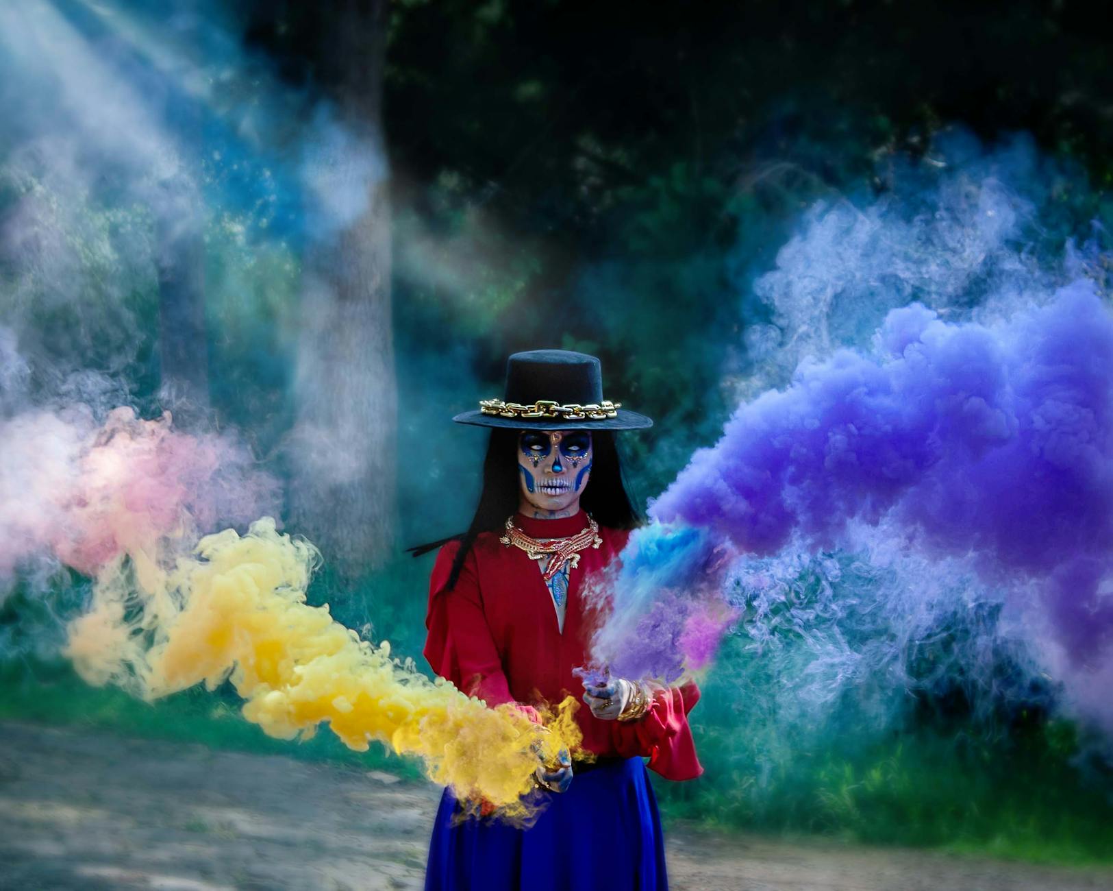 A vibrant Day of the Dead celebration with colorful smoke outdoors.