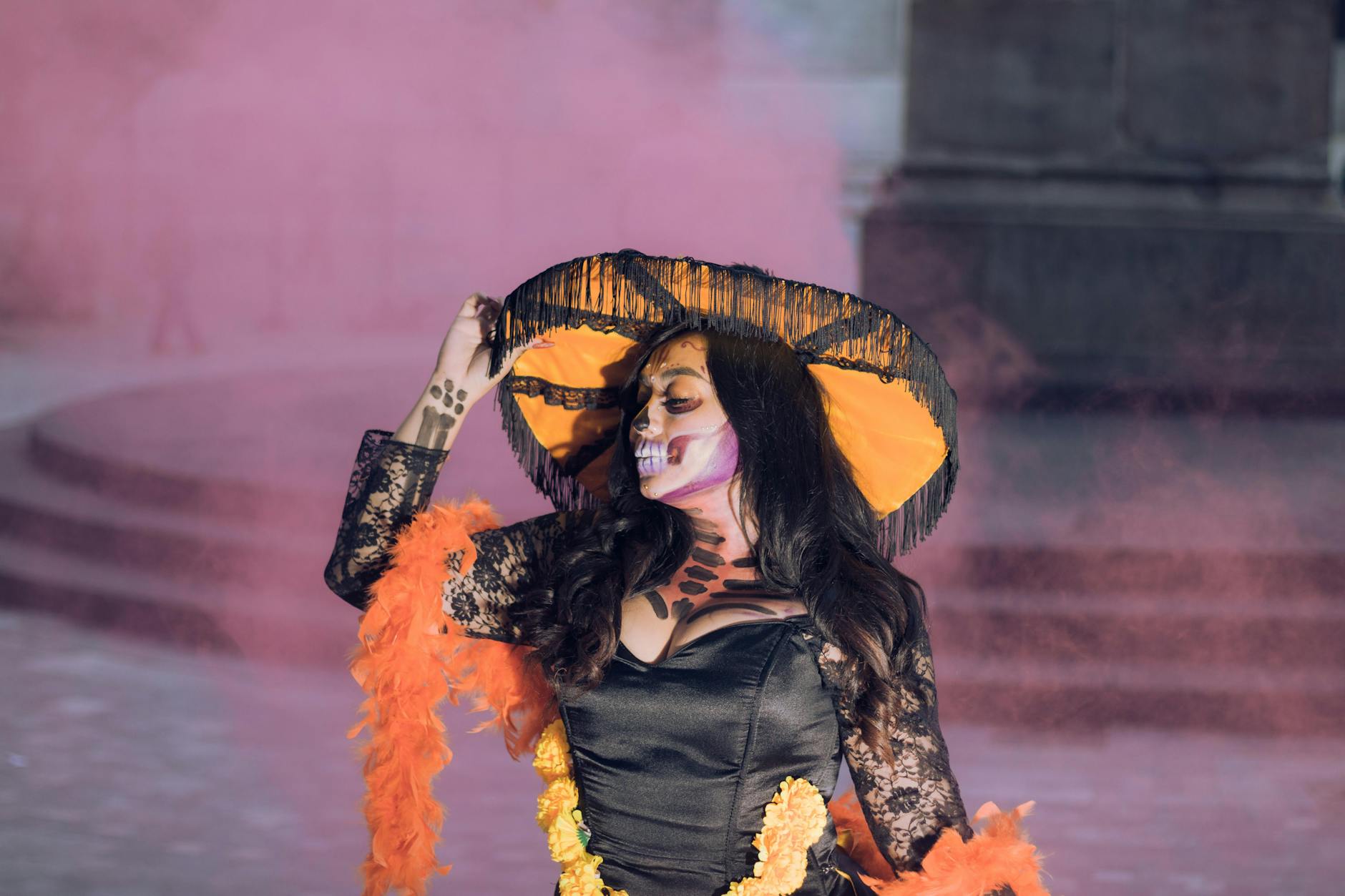 Colorful portrait of a woman celebrating Dia de Muertos with traditional costume and makeup.