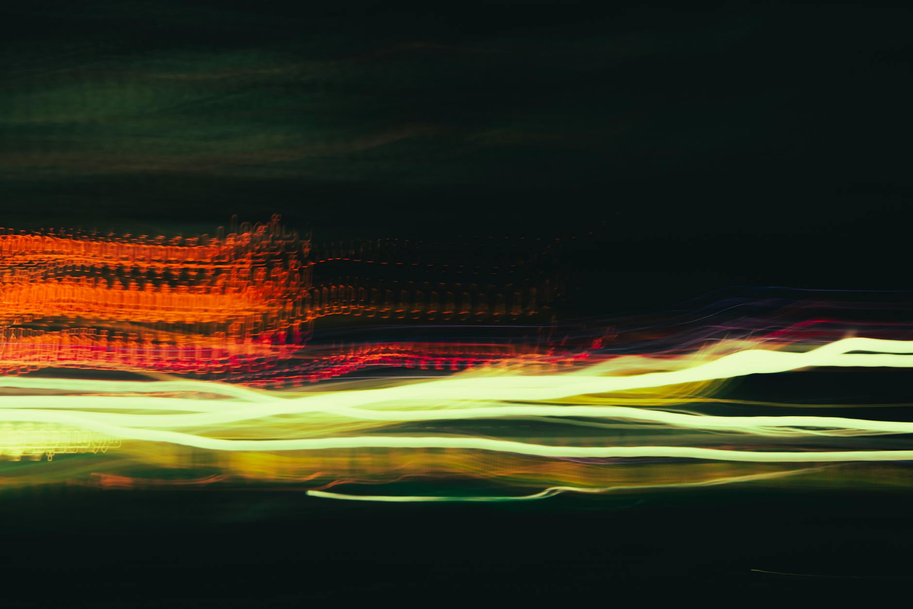 Colorful long exposure light trails create an abstract, dynamic night scene.