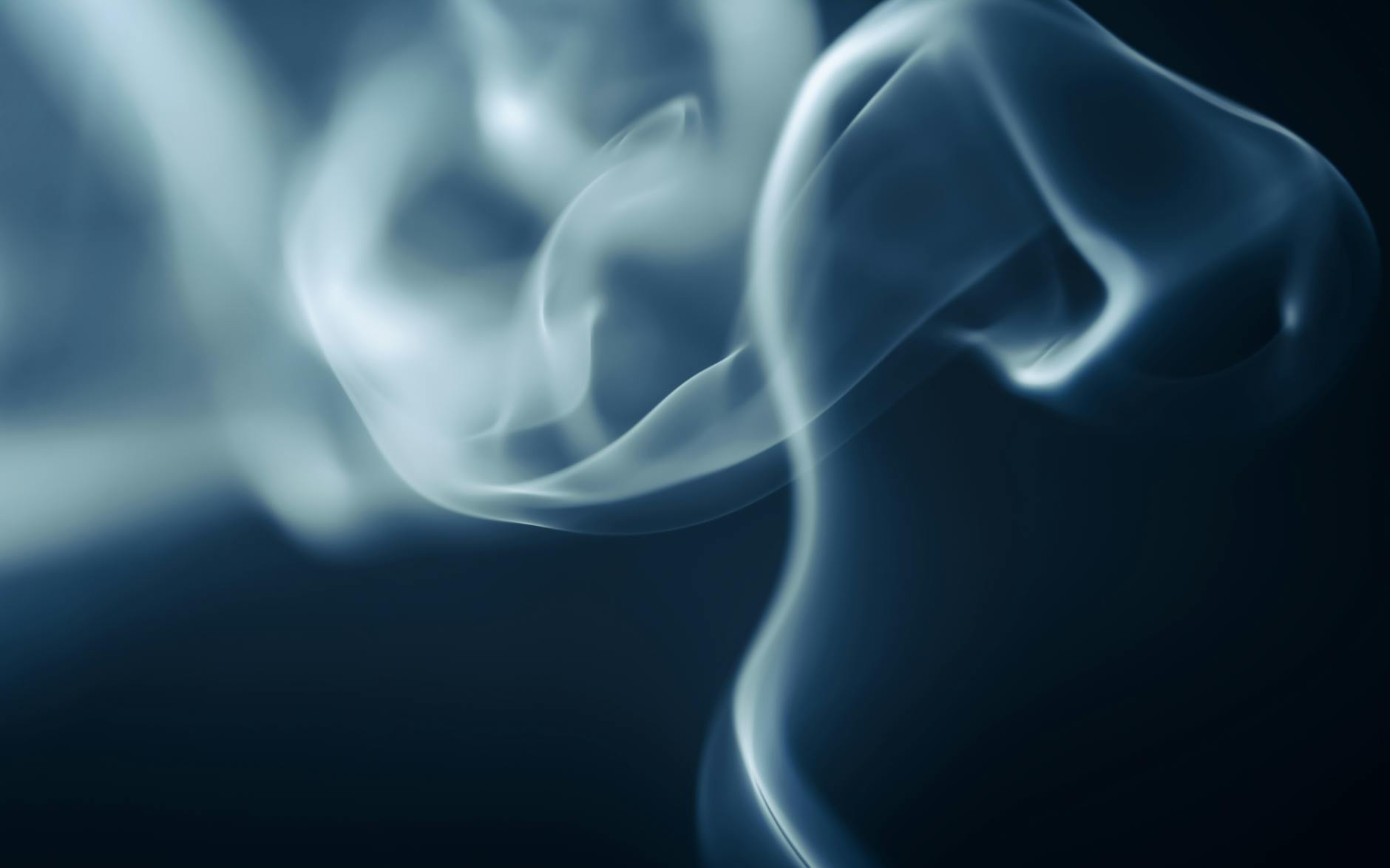 Abstract close-up of ethereal smoke swirls against a dark backdrop, creating a mysterious and captivating mood.