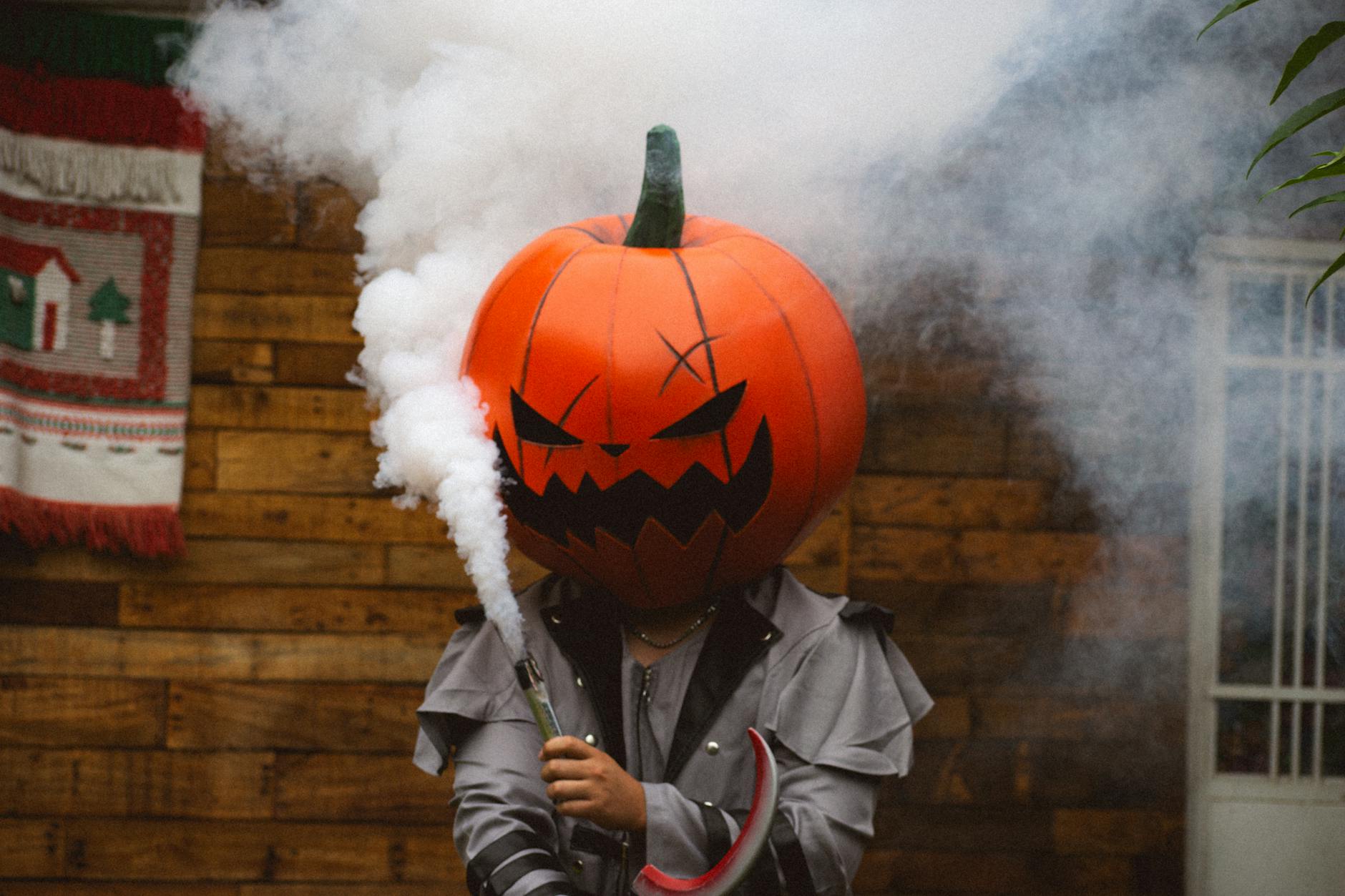 Person in pumpkin costume emitting smoke for Halloween festivities.