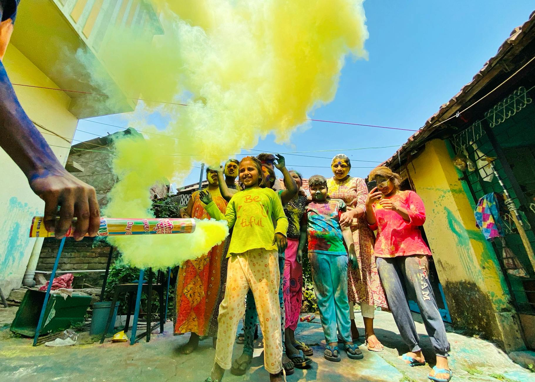 Group of children enjoying Holi in India, surrounded by vibrant yellow powder.