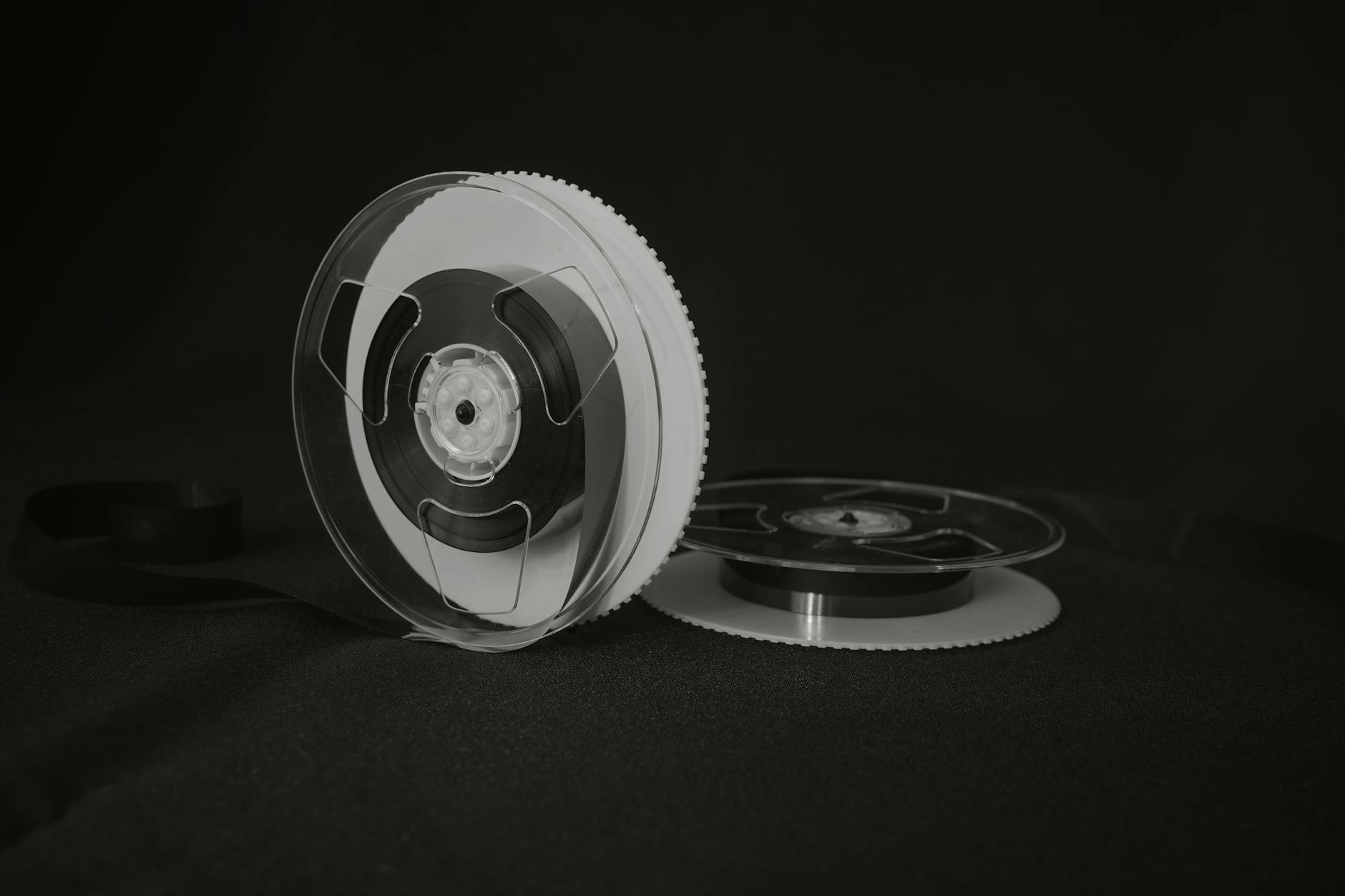 Close-up of a vintage reel-to-reel audio tape on a black background, showcasing retro recording technology.
