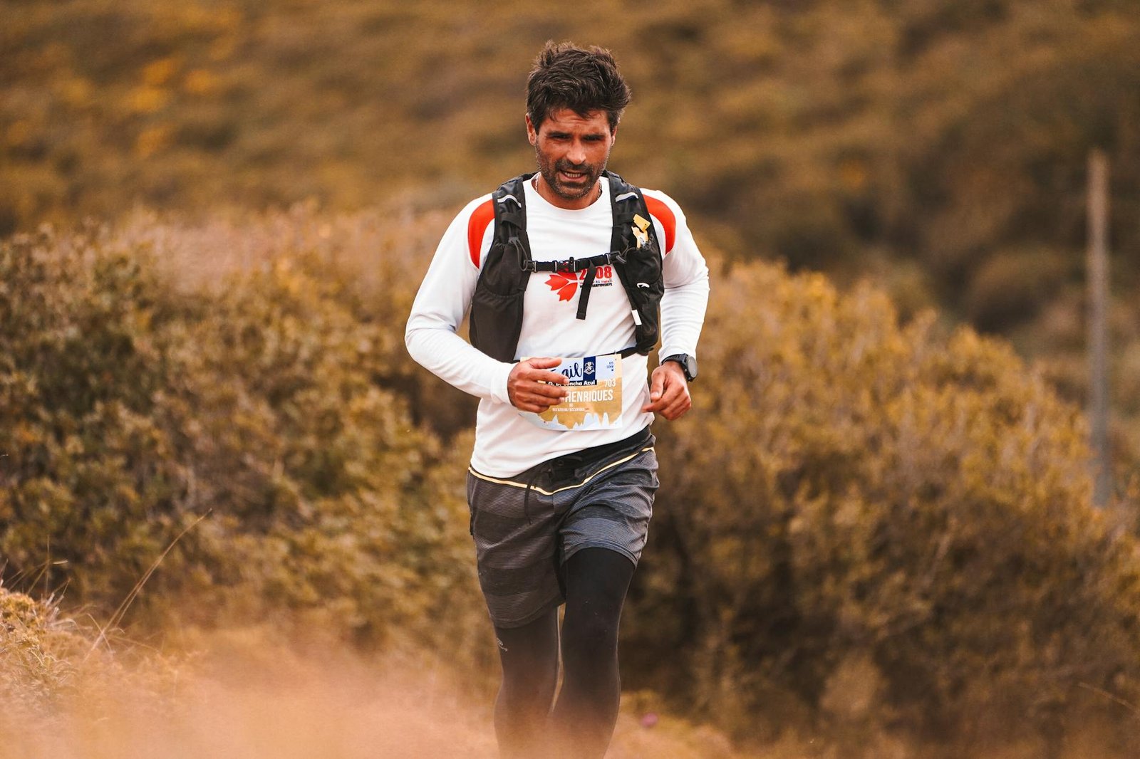 A determined man running through a scenic nature trail, embracing outdoor fitness and adventure.
