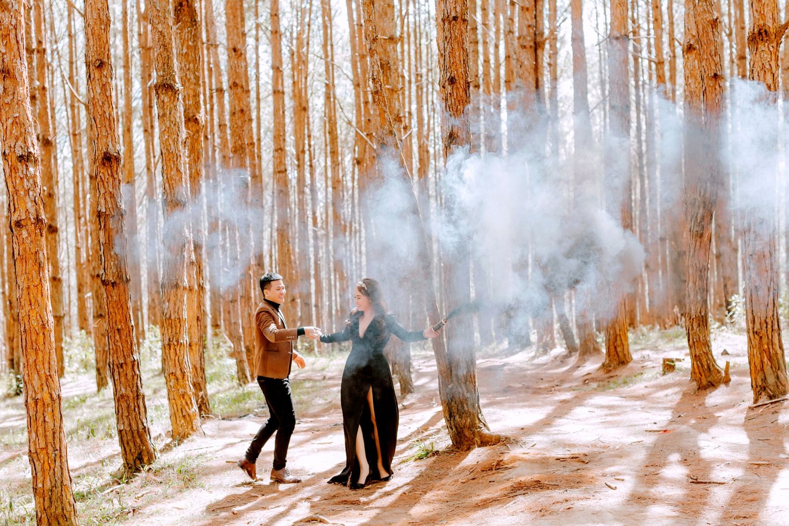 Stylish couple in a forest with smoke effects, perfect for prewedding themes.