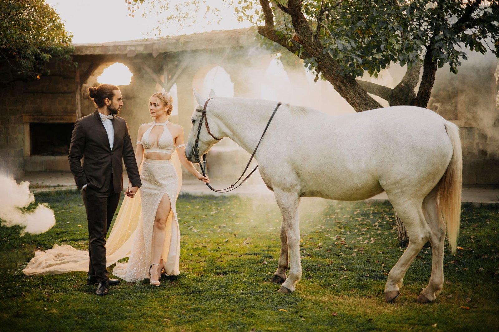 A sophisticated couple with a white horse in a serene outdoor setting in Türkiye, capturing elegance and romance.
