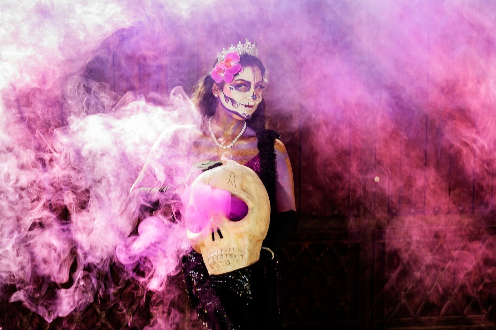 A colorful portrayal of Dia de los Muertos with traditional makeup and skull.