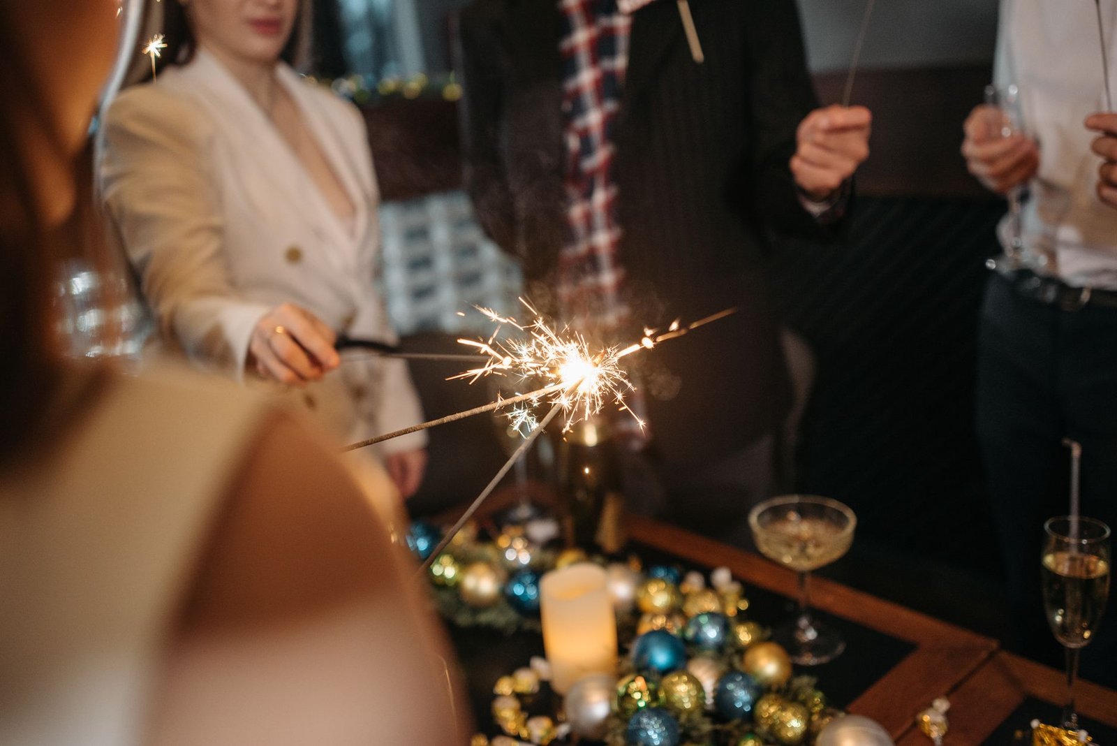 A festive indoor celebration featuring sparklers, drinks, and colorful decorations, ideal for New Year's events.