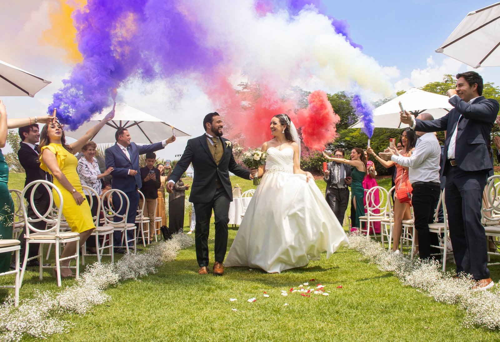 A joyful wedding celebration with colorful smoke in León, México.