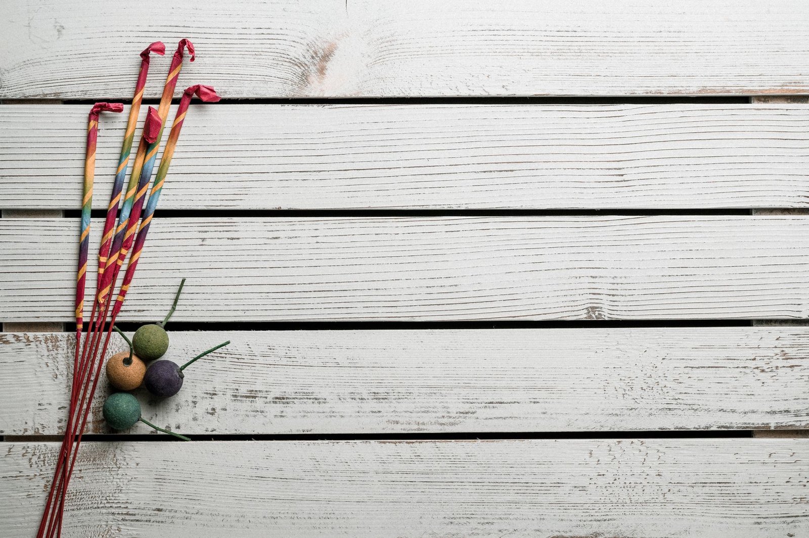 Overhead view of colorful sticks near tropical fruits on wooden planks during festive event