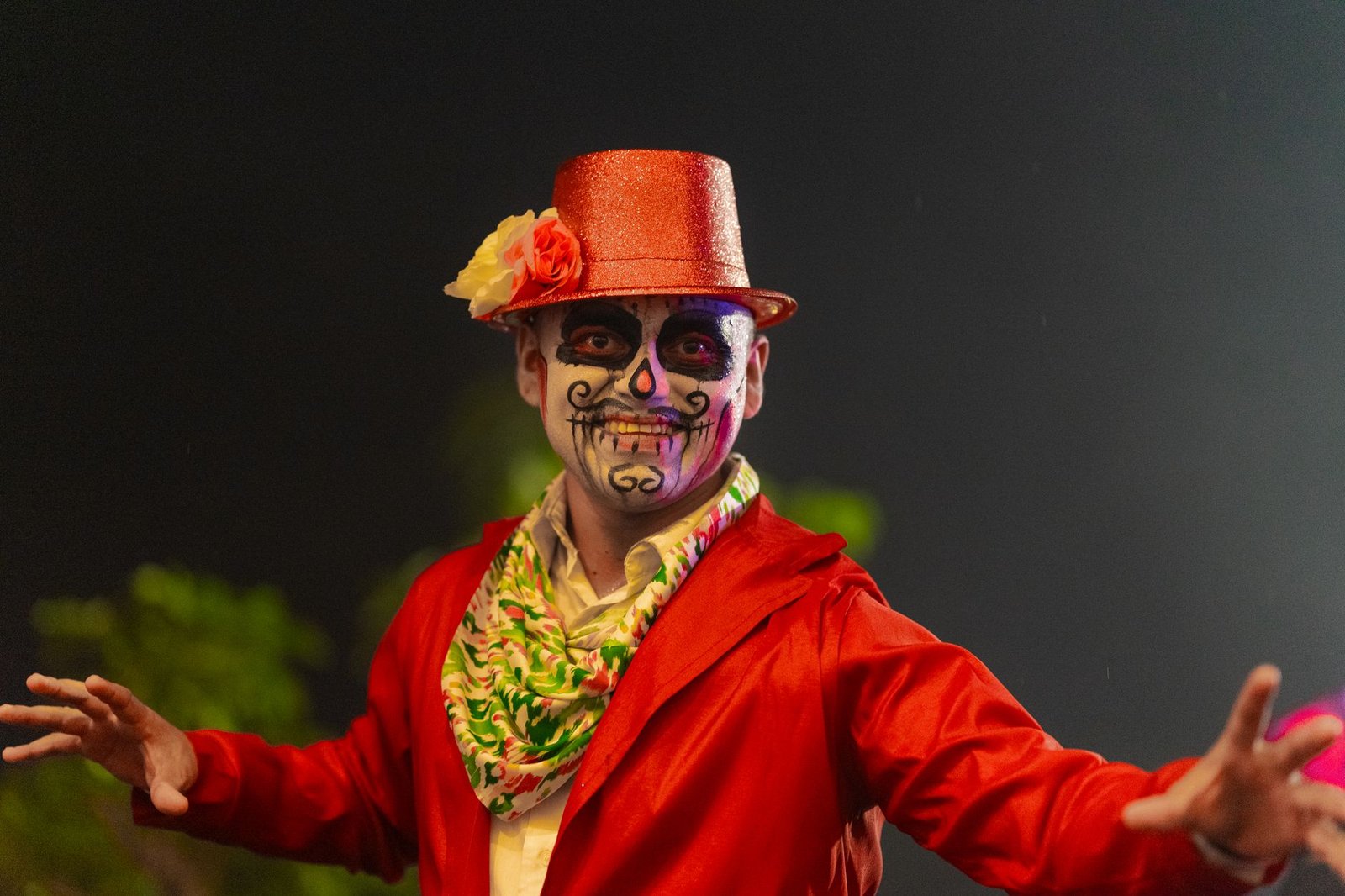 Colorful Day of the Dead celebration with a person in traditional makeup and attire in Merida, Mexico.