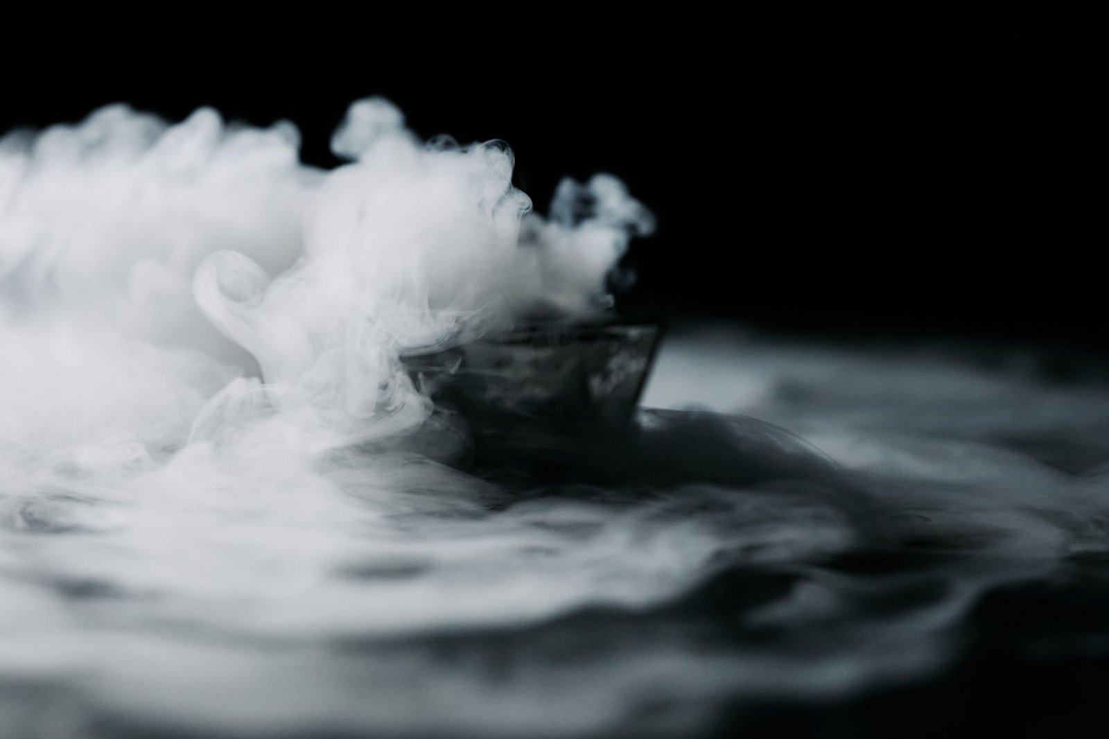 Ethereal wisps of smoke artfully drifting against a dark backdrop.
